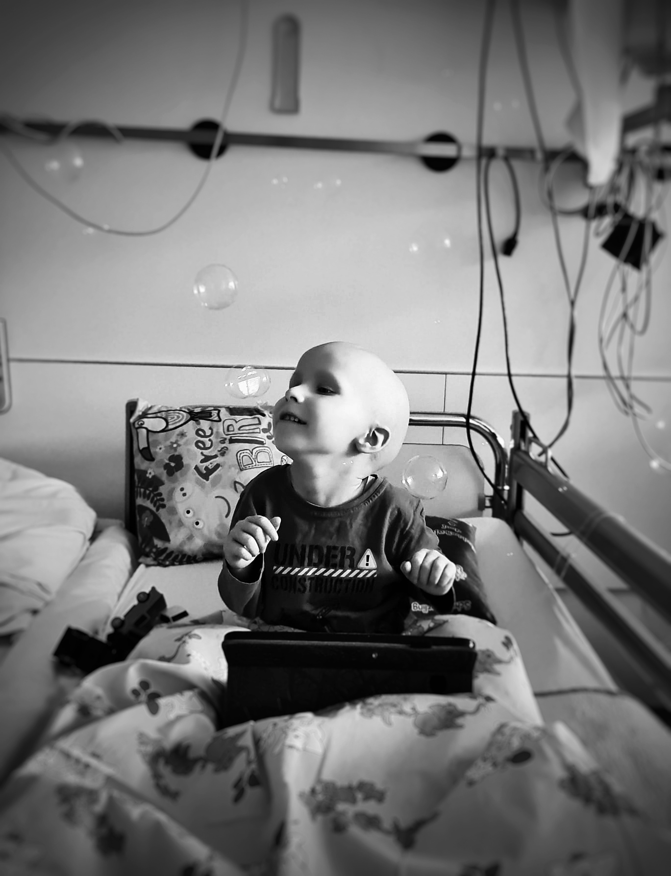 Thore im Krankenhausbett mit Seifenblasen.