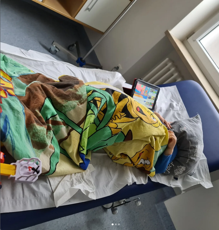 Thore liegt während eines langen Behandlungstages im Krankenhaus auf einer Liege.