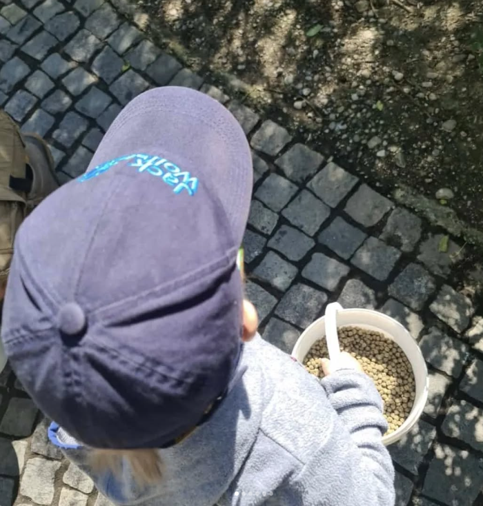 Thore hält im Tierpark einen Eimer mit Futter in der Hand.