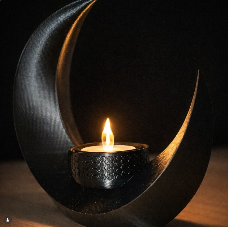 Ein 3D-gedrucktes Mondlicht mit Kerze steht auf einem dunklen Tisch.