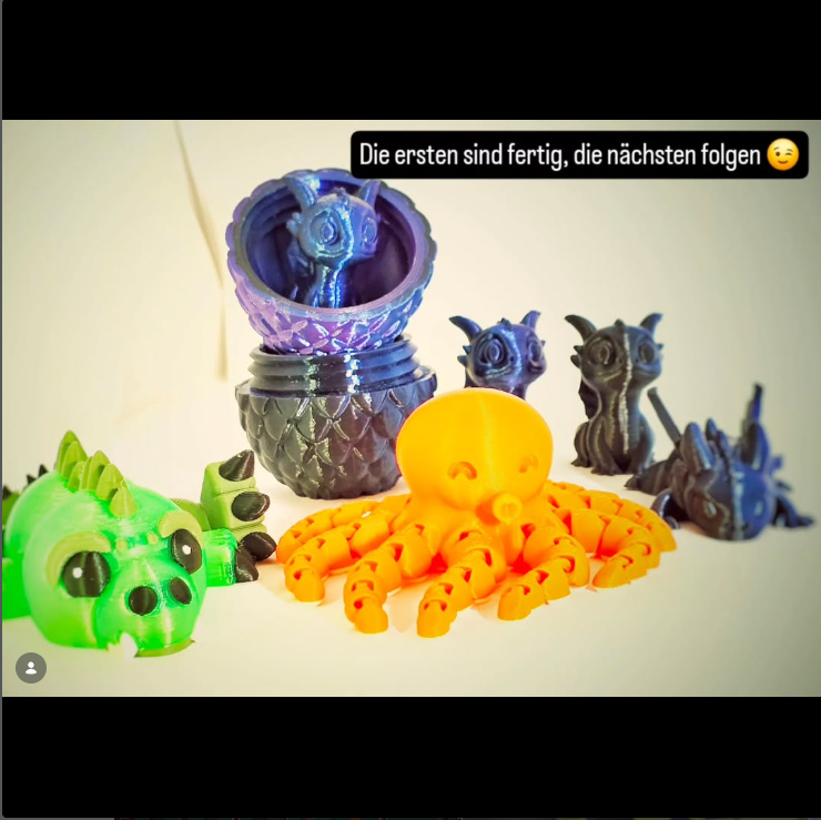 Fertige 3D-gedruckte Figuren und Beh&auml;lter sind auf einem hellen Hintergrund angeordnet.